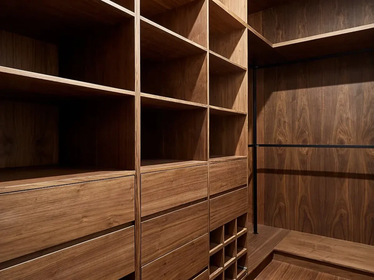 Interior de clóset a la medida con cajonería, entrepaños y tubo de colgado en madera